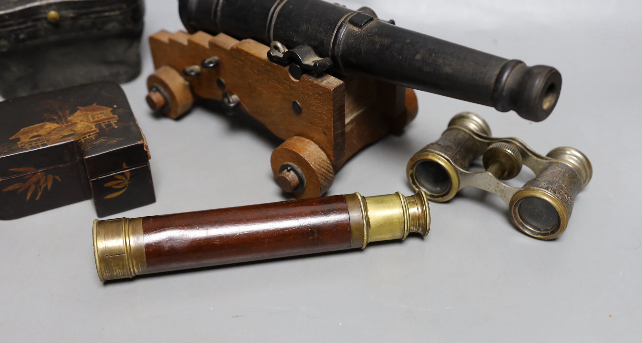 A model cast iron cannon on oak carriage, 26 cm long, two pairs of opera glasses, a telescope and lacquer box